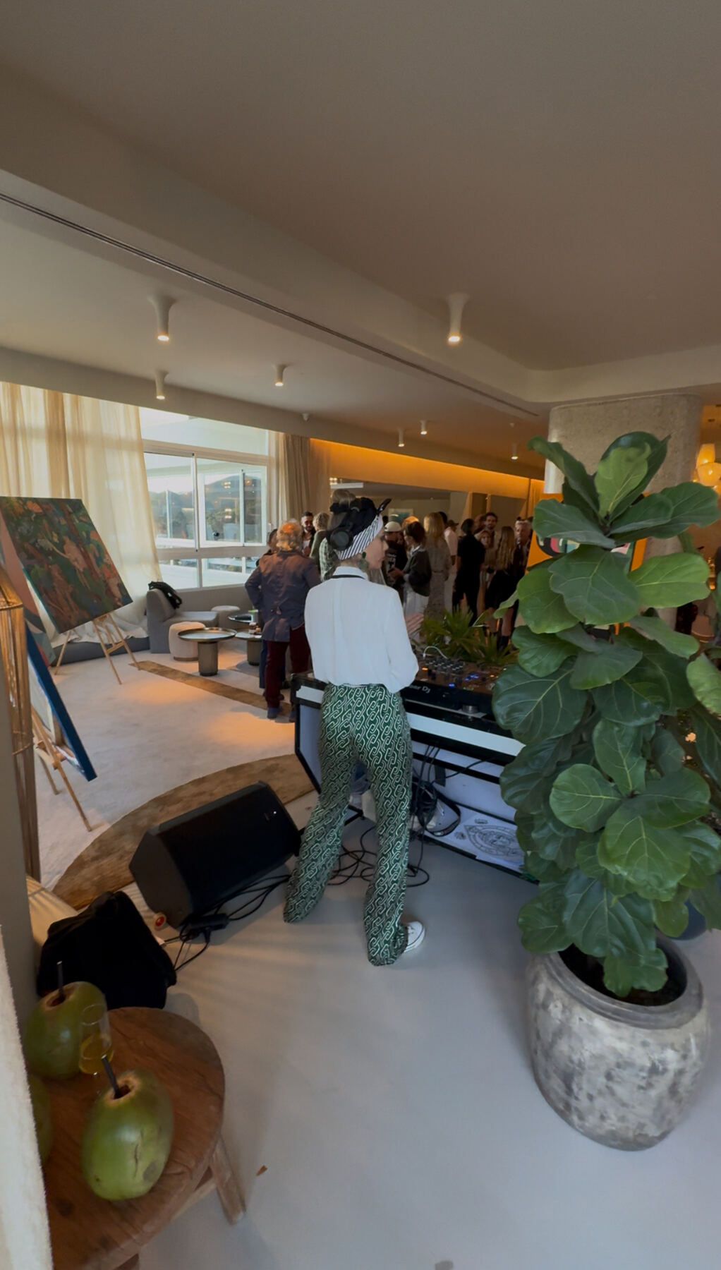 DJ set in the lounge — live painting in the background at golden hour.